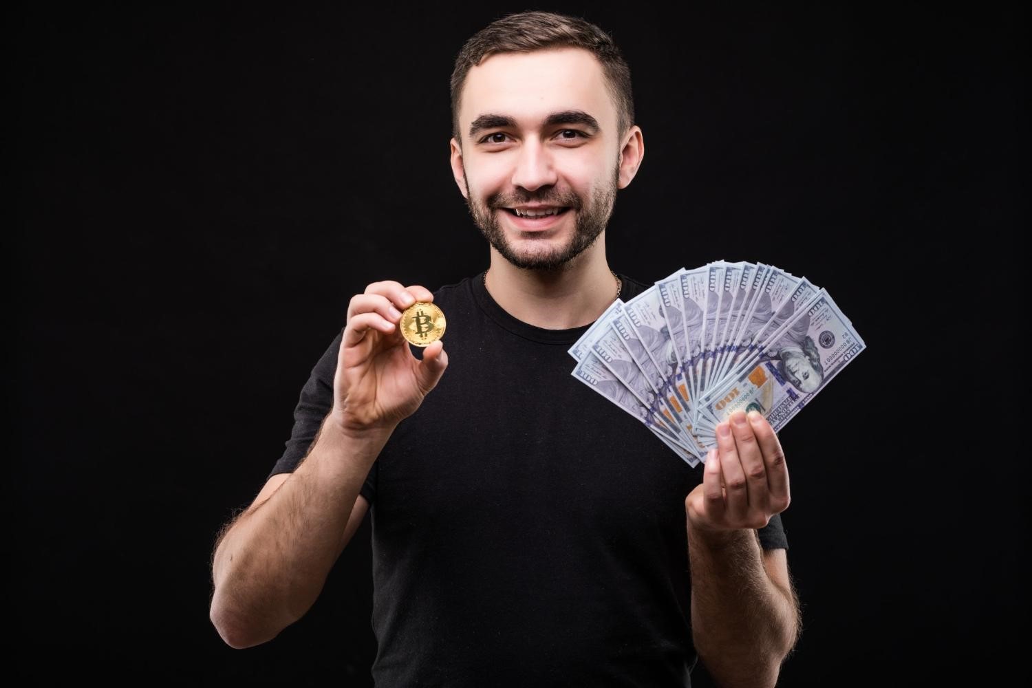 A man holding a crypto coin and bills (Image by diana.grytsku on Freepik)